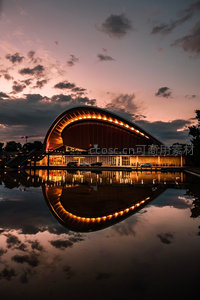 黄昏湖面倒影中的现代弧形建筑