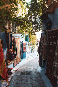 蓝墙小巷挂满手工地毯的市集一角