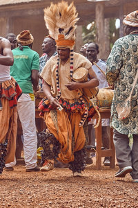 传统舞者身着盛装，头戴羽冠击鼓起舞
