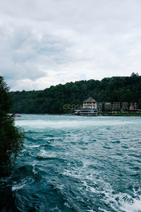 湍急河流旁的湖畔小镇与茂密森林