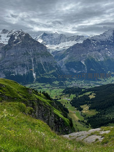 滑翔伞翱翔于山谷绿野之上