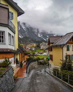 云雾锁峰小镇静，彩色屋舍沿坡建