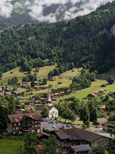 云雾缭绕阿尔卑斯山谷小镇，教堂尖顶点缀绿意田园