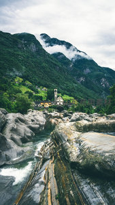 云雾缭绕山谷中的古老教堂：溪流穿石，绿意盎然