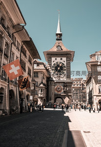 伯尔尼钟楼门矗立老城中心，行人穿梭于石板街巷与历史旗帜之间