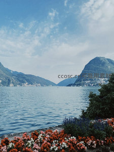 湖畔花坛映衬群山倒影，科莫湖静谧蓝调风光
