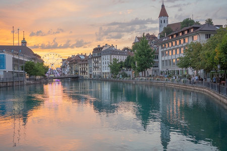 黄昏河畔城市风光，摩天轮倒影与钟楼相映成趣