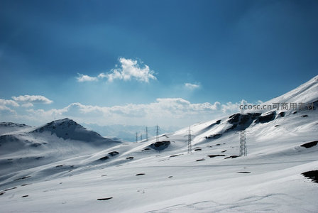 雪域高原输电塔：苍茫雪山间钢铁骨架延伸至天际线