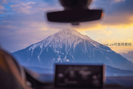 车内视角望雪山日出，后视镜与仪表盘点缀旅途诗意