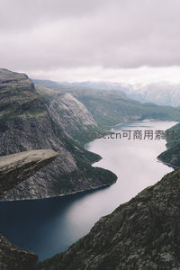 挪威峡湾巨岩悬空，深蓝水域蜿蜒穿行于陡峭青山之间
