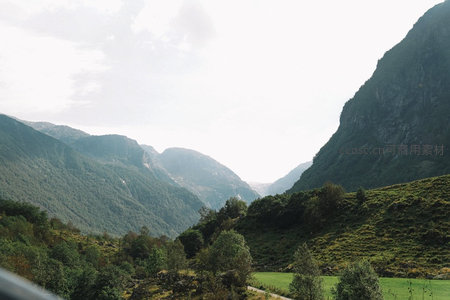 绿谷环抱深峡，阳光穿透云隙洒在葱郁山坡与农田之上