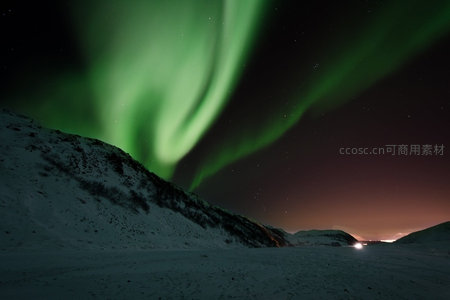 雪岭之上绿光舞动，极光如绸带划破寒夜星空