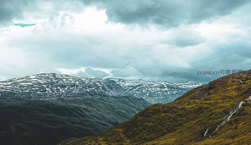 云雾缭绕的阿尔卑斯山脊，残雪斑驳绿野延绵起伏