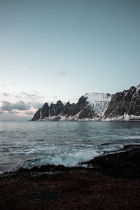 锯齿状岩峰刺破天际，海浪轻拍黑滩，冷调晨昏静谧辽阔