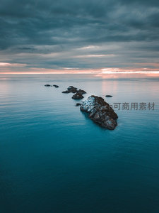 航拍海中孤岩群落，暮色云层映照碧蓝海面