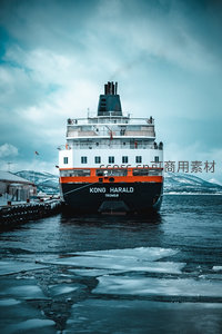 ‘KONG HARALD’号渡轮正面对镜拍摄，橙白黑三色船身醒目，远山覆雪静默守望