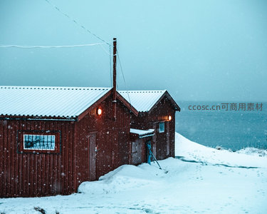 暴雪中红屋暖光映照海岸线