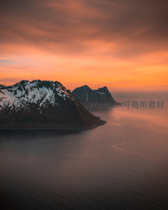 橙红晚霞映照雪山海岸，海面波光粼粼