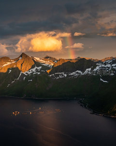 暴雨初歇彩虹横跨雪峰峡湾，渔场浮标静卧幽深水域