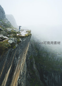 雾锁险崖：撑伞旅人独行于层理分明的悬空石径，云海漫卷