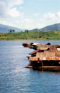 湄公河畔水上村落，竹木屋舍漂浮于碧波青山之间