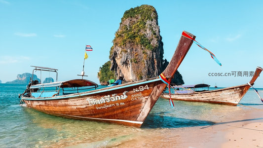 泰国甲米长尾船停泊浅滩，喀斯特岩峰耸立蓝天之下