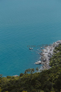 航拍碧海礁岸，绿林环抱嶙峋石滩与孤岛