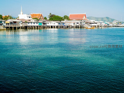 泰国海滨渔村木屋群落，红顶佛寺映衬碧海蓝天的宁静港湾
