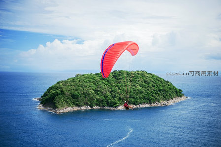 滑翔伞掠过葱郁小岛，碧海环绕，天空云卷云舒