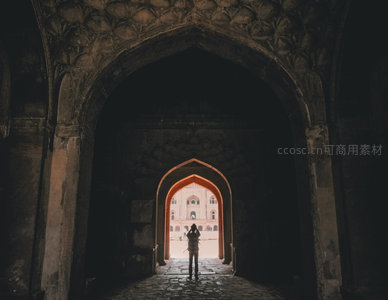 阿格拉堡拱门剪影摄影，游客伫立门洞远眺红堡，光影对比强烈