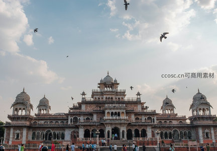 斋浦尔城市宫殿前鸽群飞舞，古典建筑与蓝天白云相映成趣