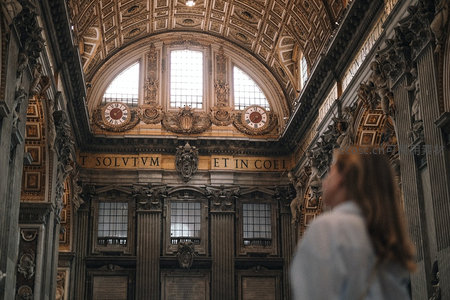 梵蒂冈博物馆内景，游客凝望华丽拱顶与拉丁铭文‘SOLVTVM ET IN COEL’