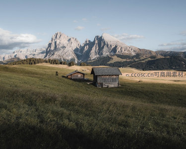 阿尔卑斯山脚下草甸上的古老木屋与壮丽岩峰