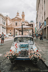 彩色涂鸦老式菲亚特500停于西西里街巷，鲜花点缀复古风情