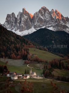 秋日阿尔卑斯山谷，金色林海环抱古朴山村与雪顶圣山
