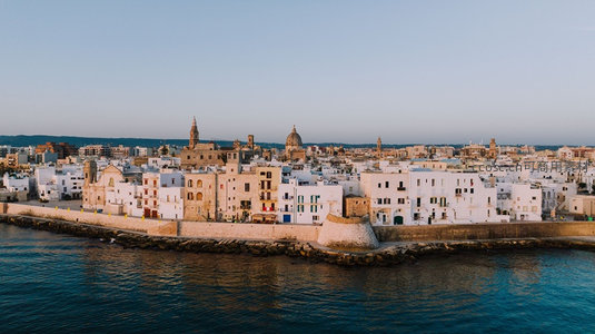 白色海滨古城依崖而建，穹顶教堂与石砌防波堤共绘地中海风情