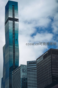 蓝绿玻璃幕墙摩天楼刺破云层，现代都市几何美学