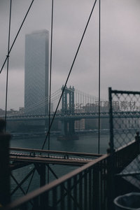 雾中曼哈顿大桥与摩天楼剪影，铁索交织的静谧都市
