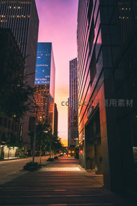 都市峡谷日落时分，紫橙渐变天空映照玻璃幕墙摩天楼群