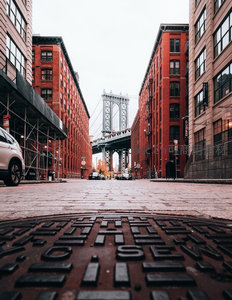 纽约DUMBO街区仰拍视角，曼哈顿大桥穿行红砖建筑间