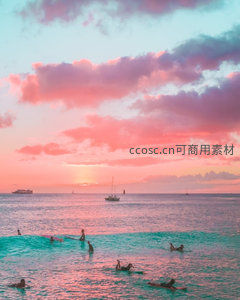 粉紫晚霞下的冲浪者剪影，海面波浪与帆船共绘热带黄昏画卷