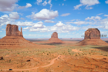 纪念碑谷广角全景：砂岩孤峰矗立荒漠，越野车穿行土路