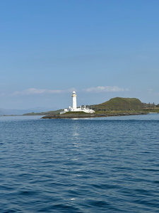 碧海孤岛上的白色灯塔在晴空下静谧矗立