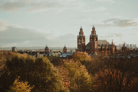 秋日余晖洒落格拉斯哥大学，红砖尖塔与金黄树冠交相辉映