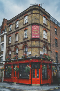 金鹰酒馆红砖转角老店，花篮点缀门廊，典型伦敦维多利亚风格街景