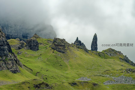 苏格兰斯凯岛老人峰雾中矗立，翠绿山坡与嶙峋玄武岩柱形成奇观