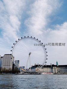 伦敦眼摩天轮矗立泰晤士河畔，蓝天白云下尽显都市休闲魅力