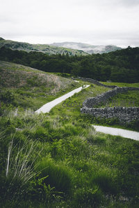 蜿蜒石径穿行翠绿山谷，古老干石墙环绕田园风光