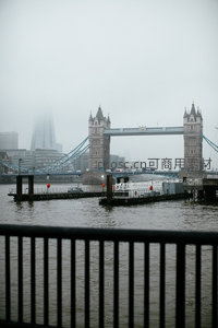 透过栏杆远眺雾中塔桥，水面微澜倒映朦胧天际线