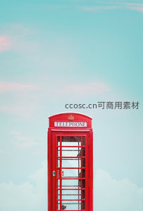 经典红色电话亭矗立于淡蓝天空下，复古英伦风情尽显